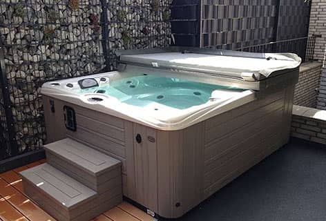 Weiß-grauer Whirlpool in Holzoptik und Trittstufen