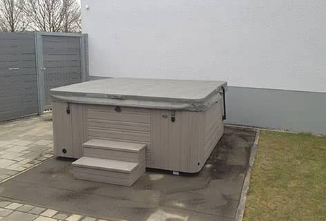 Outdoor Massage-Whirlpool auf dem gepflasterten Gartenbereich