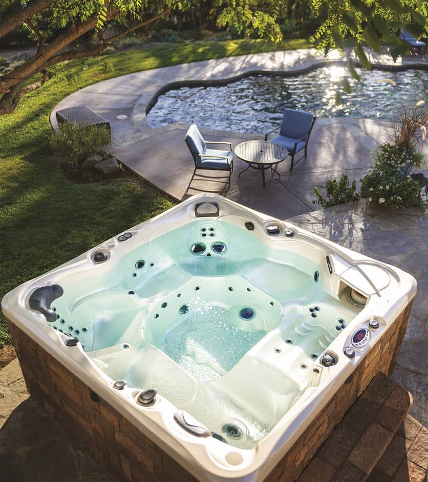 Eine Familie relaxt im und am Whirlpool